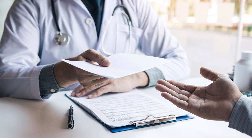 Arzt händigt Kostenblatt aus